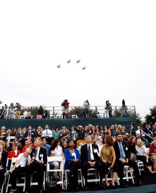 NASA image: KENNEDY SPACE CENTER, FLA. -- Family members of the STS-107 astronauts and other dignitaries watch NASA T-38 jets fly over the Space Mirror Memorial at the Kennedy Space Center Visitor Complex in a Missing Man Formation. During this dedication ceremony, the names of the STS-107 astronauts who lost their lives during the Columbia accident -- Rick Husband, Willie McCool, Laurel Clark, Michael Anderson, David Brown, Kalpana Chawla, and Ilan Ramon -- join the names of 17 other space heroes who gave their lives for the U.S. space program.