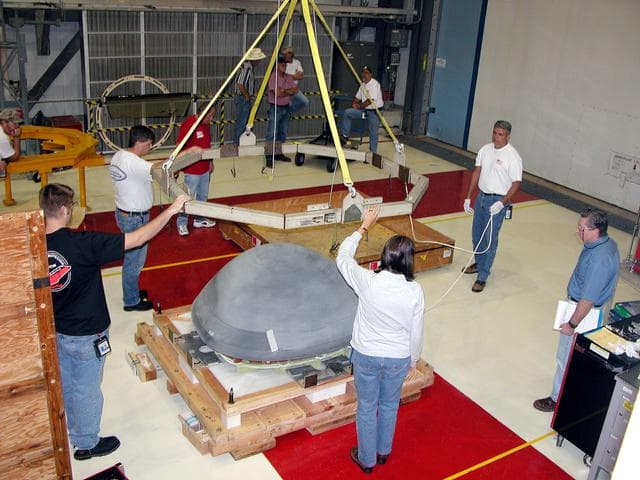 NASA image: KENNEDY SPACE CENTER, FLA. -  In the Orbiter Processing Facility, workers remove the overhead crane from the nose cap that was removed from Atlantis.   The reinforced carbon-carbon (RCC) nose cap is being sent to the original manufacturing company, Vought in Ft. Worth, Texas, a subsidiary of Lockheed Martin, to undergo non-destructive testing such as CAT scan and thermography.