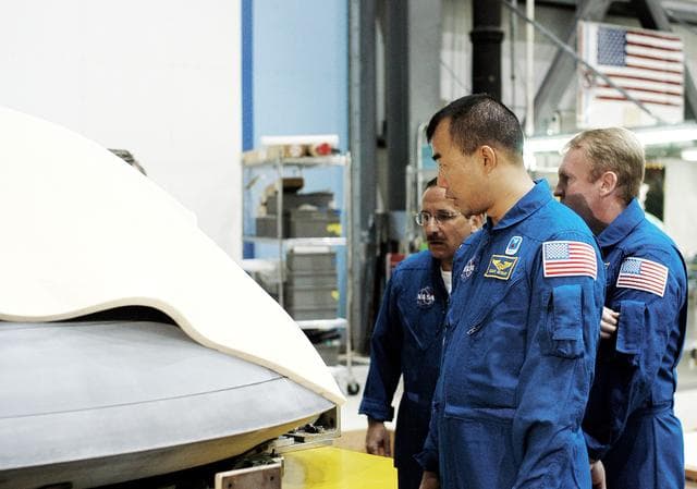 NASA image: KENNEDY SPACE CENTER, FLA. -  In the Orbiter Processing Facility, STS-114 crew members look at the nose cap recently removed from Atlantis.  From left are Mission Specialists Charles Camarda, Soichi Noguchi, and Andy Thomas.  Camarda and Thomas are new additions to the crew.  Noguchi is with the Japan Aerospace Exploration Agency, JAXA. The STS-114 crew is at KSC to take part in crew equipment and orbiter familiarization.
