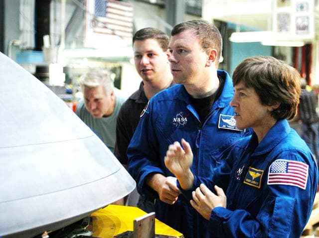 NASA image: KENNEDY SPACE CENTER, FLA. -  In the Orbiter Processing Facility, STS-114 Pilot James Kelly (center) and Mission Specialist Wendy Lawrence, who was recently added to the mission crew, look at the nose cap recently removed from Atlantis. The STS-114 crew is at KSC to take part in equipment familiarization.