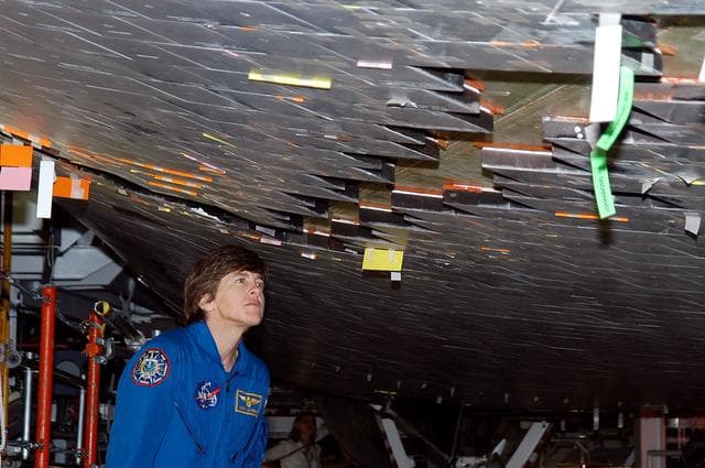 NASA image: KENNEDY SPACE CENTER, FLA. -  In the Orbiter Processing Facility, STS-114 Mission Specialist Wendy Lawrence takes a close look at the some of the tiles underneath Atlantis.  Lawrence is a new addition to the mission crew.  The STS-114 crew is at KSC to take part in crew equipment and orbiter familiarization.