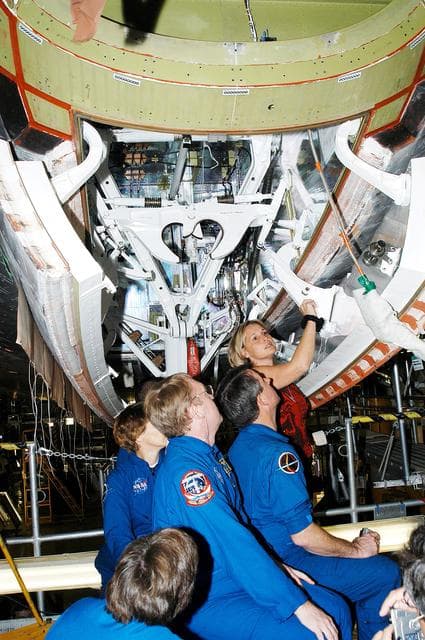 NASA image: KENNEDY SPACE CENTER, FLA. -  Members of the STS-114 crew look over Shuttle equipment in the Orbiter Processing Facility.  In the foreground is Mission Specialist Wendy Lawrence, who is a new addition to the crew.  Behind her are (left to right) Commander Eileen Collins and Mission Specialists Andy Thomas and Stephen Robinson.  At the rear is Glenda Laws, EVA Task Leader, with United Space Alliance at Johnson Space Center.  The STS-114 crew is at KSC to take part in crew equipment and orbiter familiarization.