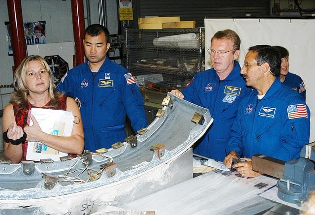 NASA image: KENNEDY SPACE CENTER, FLA. - Members of the STS-114 crew look over flight  equipment in the Orbiter Processing Facility.  From left are Glenda Laws, EVA Task Leader, with United Space Alliance at Johnson Space Center, Mission Specialists Soichi Noguchi, Andy Thomas, Charles Camarda and Wendy Lawrence. Noguchi is with the Japan Aerospace Exploration Agency, JAXA.  Not seen are Mission Commander Eileen Collins, Pilot James Kelly and Mission Specialist Stephen Robinson. The STS-114 crew is at KSC to take part in crew equipment and orbiter familiarization.