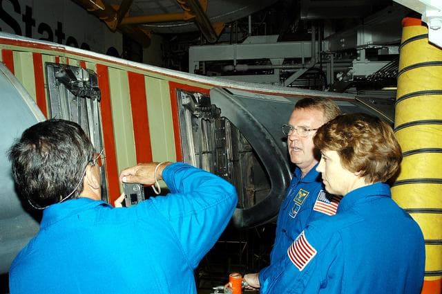 NASA image: KENNEDY SPACE CENTER, FLA. -   In the Orbiter Processing Facility, STS-114 crew members look at the reinforced carbon-carbon panels on the wing of Atlantis. From left are Mission Specialists Charles Camarda and Andrew Thomas and Commander Eileen Collins.  The STS-114 crew is at KSC to take part in crew equipment and orbiter familiarization.