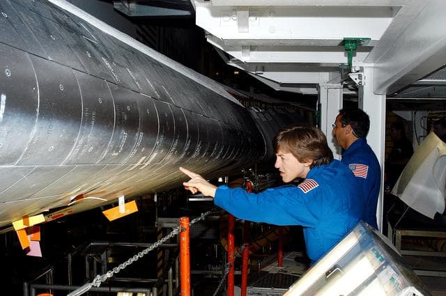 NASA image: KENNEDY SPACE CENTER, FLA. -   In the Orbiter Processing Facility, STS-114 crew members look at the tiles on the wing of Atlantis. In the foreground is Mission Specialist Wendy Lawrence, who is a new addition to the mission crew.  Behind her is Mission Specialist Charles Camarda, also a new addition.  The STS-114 crew is at KSC to take part in crew equipment and orbiter familiarization.