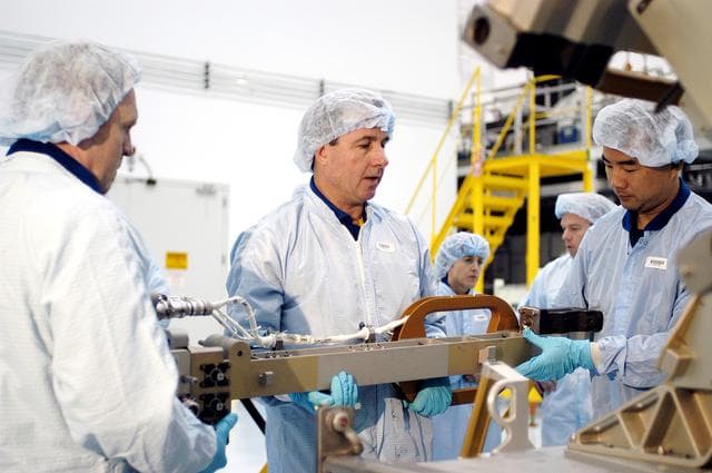 NASA image: KENNEDY SPACE CENTER, FLA. - In the Space Station Processing Facility, STS-114 crew members get hands-on experience with a Video Stanchion Support Assembly (VSSA).  From left are Mission Specialists Andrew Thomas, Stephen Robinson and Soichi Noguchi, who is with the Japan Aerospace Exploration Agency, JAXA.  Thomas is a new addition to the mission crew. The STS-114 crew is at KSC to take part in crew equipment and orbiter familiarization.