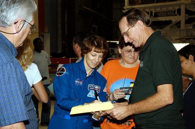 NASA image: KENNEDY SPACE CENTER, FLA. - STS-114 Mission Commander Eileen Collins signs autorgraphs for workers in the Orbiter Processing Facility.   The STS-114 crew is at KSC to take part in crew equipment and orbiter familiarization.