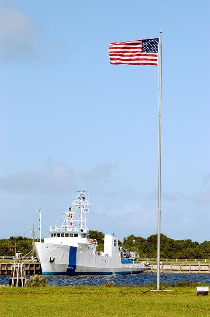 NASA image: KENNEDY SPACE CENTER, FLA. -  The Freedom Star is berthed at the Turn Basin near the Vehicle Assembly Building and NASA-KSC News Center.  The flag is near the News Center.   The ship has recently returned to KSC after refurbishment at Fort George Island, Fla., including new paint.  Freedom Star is one of the solid rocket booster (SRB) retrieval ships built to recover the SRB casings released over the Atlantic Ocean after launch of a Space Shuttle.  In addition to the SRBs, the ship recovers the drogue and main parachutes that slow the boosters’ speed before splashdown.   The ships also tow the external tanks built at the Michoud Space Systems Assembly Facility near New Orleans to Port Canaveral, Fla.  Freedom Star was brought to KSC today for a visit by NATO Parliamentarians.