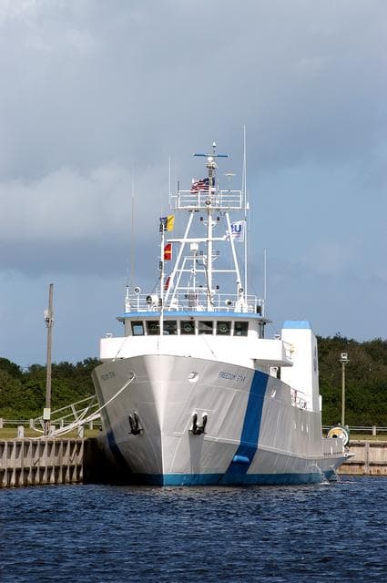 NASA image: KENNEDY SPACE CENTER, FLA. -  The Freedom Star is berthed at the Turn Basin near the Vehicle Assembly Building.  The ship has recently returned to KSC after refurbishment at Fort George Island, Fla., including new paint.  Freedom Star is one of the solid rocket booster (SRB) retrieval ships built to recover the SRB casings released over the Atlantic Ocean after launch of a Space Shuttle.  In addition to the SRBs, the ship recovers the drogue and main parachutes that slow the boosters’ speed before splashdown.   The ships also tow the external tanks built at the Michoud Space Systems Assembly Facility near New Orleans to Port Canaveral, Fla.  Freedom Star was brought to KSC today for a visit by NATO Parliamentarians.