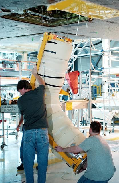 NASA image: KENNEDY SPACE CENTER, FLA. -   In the Orbiter Processing Facility, workers lift the liquid oxygen feedline for the 17-inch disconnect toward orbiter Discovery for installation. The 17-inch liquid oxygen and liquid hydrogen disconnects provide the propellant feed interface from the external tank to the orbiter main propulsion system and the three Shuttle main engines.
