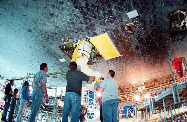 NASA image: KENNEDY SPACE CENTER, FLA. - In the Orbiter Processing Facility, workers install the liquid oxygen feedline for the 17-inch disconnect on orbiter Discovery. The 17-inch liquid oxygen and liquid hydrogen disconnects provide the propellant feed interface from the external tank to the orbiter main propulsion system and the three Shuttle main engines.