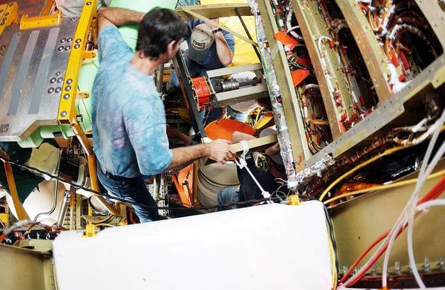 NASA image: KENNEDY SPACE CENTER, FLA. -  Viewed from inside the aft section of the orbiter Discovery, a worker installs the liquid oxygen feedline for the 17-inch disconnect, coming up from below. The 17-inch liquid oxygen and liquid hydrogen disconnects provide the propellant feed interface from the external tank to the orbiter main propulsion system and the three Shuttle main engines.
