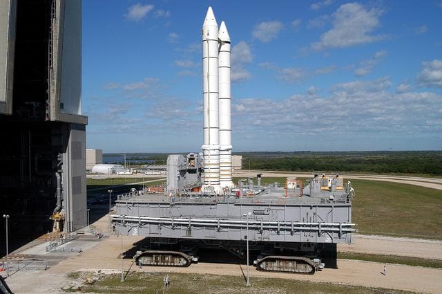NASA image: KENNEDY SPACE CENTER, FLA. -  Mobile Launcher Platform (MLP) number 3 and a set of twin solid rocket boosters, atop the crawler-transporter, inch away from the Vehicle Assembly Building (VAB) in support of the second engineering analysis vibration test on the crawler and MLP. The crawler is moving at various speeds up to 1 mph in an effort to achieve vibration data gathering goals as it leaves the VAB, travels toward Launch Pad 39A and then returns.  The boosters are braced at the top for stability.  The primary purpose of these rollout tests is to gather data to develop future maintenance requirements on the transport equipment and the flight hardware. Various parts of the MLP and crawler transporter have been instrumented with vibration data collection equipment.