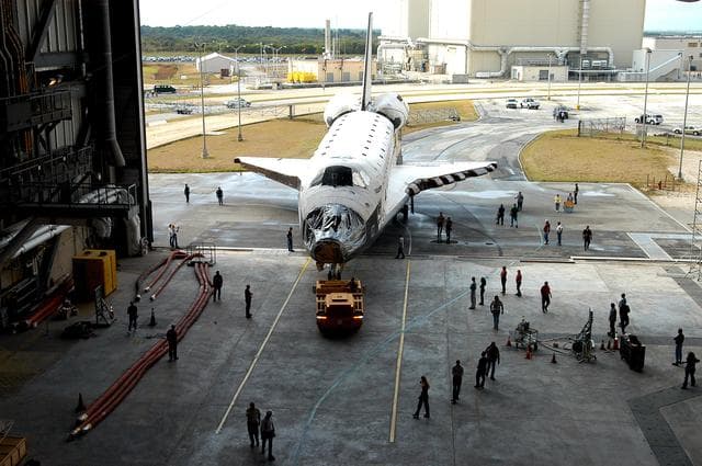NASA image: KENNEDY SPACE CENTER, FLA. - The Space Shuttle orbiter Atlantis moves into high bay 4 of the Vehicle Assembly Building (VAB).  It was towed from the Orbiter Processing Facility (OPF) to allow work to be performed in the bay that can only be accomplished while it is empty. Work scheduled in the processing facility includes annual validation of the bay's cranes, work platforms, lifting mechanisms, and jack stands. Atlantis will remain in the VAB for about 10 days, then return to the OPF as work resumes to prepare it for launch in September 2004 on the first return-to-flight mission, STS-114.
