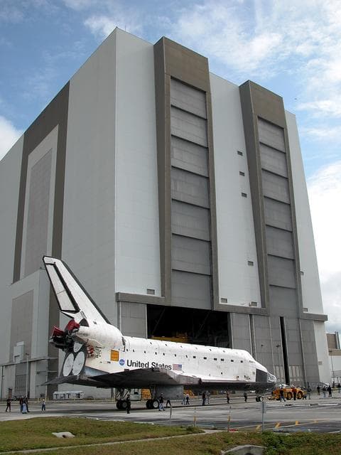 NASA image: KENNEDY SPACE CENTER, FLA. - The Space Shuttle orbiter Atlantis approaches the Vehicle Assembly Building (VAB) high bay 4.  It is being towed from the Orbiter Processing Facility (OPF) to allow work to be performed in the bay that can only be accomplished while it is empty. Work scheduled in the processing facility includes annual validation of the bay's cranes, work platforms, lifting mechanisms, and jack stands. Atlantis will remain in the VAB for about 10 days, then return to the OPF as work resumes to prepare it for launch in September 2004 on the first return-to-flight mission, STS-114.