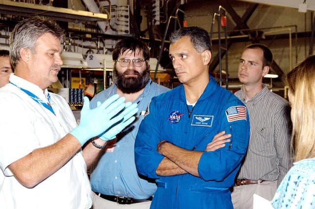 NASA image: KENNEDY SPACE CENTER, FLA. -  - In the Orbiter Processing Facility astronaut Danny Olivas listens to Greg Grantham (left) talking about the Reinforced Carbon Carbon panels used on the leading edge of the wing of the orbiters.  Behind Olivas are engineers from around the Agency who are working on improving the RCC panels used on the wing leading edge. The gray carbon composite RCC panels have sufficient strength to withstand the aerodynamic forces experienced during launch and reentry, which can reach as high as 800 pounds per square foot.  The operating range of RCC is from minus 250º F to about 3,000º F, the temperature produced by friction with the atmosphere during reentry.