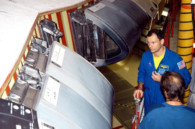 NASA image: KENNEDY SPACE CENTER, FLA. - In the Orbiter Processing Facility, astronaut Michael E. Lopez-Alegria looks at the Reinforced Carbon Carbon panels used on the leading edge of the wing of the orbiters. He and engineers from around the Agency are on a fact-finding tour for improving the RCC panels used on the wing leading edge.  The gray carbon composite RCC panels have sufficient strength to withstand the aerodynamic forces experienced during launch and reentry, which can reach as high as 800 pounds per square foot.  The operating range of RCC is from minus 250º F to about 3,000º F, the temperature produced by friction with the atmosphere during reentry.