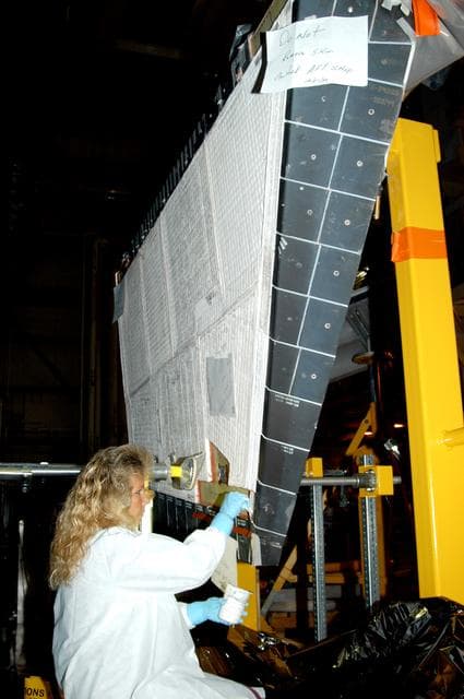 NASA image: KENNEDY SPACE CENTER, FLA. -  In the Orbiter Processing Facility, KSC employee Nadine Phillips prepares an area on the orbiter Discovery for blanket installation.  The blankets are part of the Orbiter Thermal Protection System, thermal shields to protect against temperatures as high as 3,000° Fahrenheit, which are produced during descent for landing. Discovery is scheduled to fly on mission STS-121 to the International Space Station.