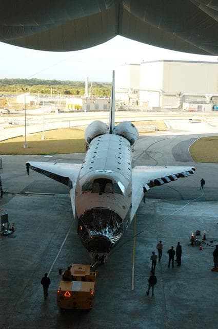 NASA image: KENNEDY SPACE CENTER, FLA. -- The orbiter Atlantis is backed out of the Vehicle Assembly Building for transfer back to the Orbiter Processing Facility.  Atlantis spent 10 days in the VAB to allow work to be performed in the OPF that can only be accomplished while the bay is empty. Work included annual validation of the bay's cranes, work platforms, lifting mechanisms and jack stands.  Work resumes to prepare Atlantis for launch in September 2004 on the first return-to-flight mission, STS-114.