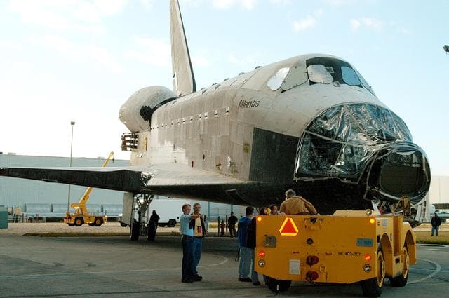 NASA image: KENNEDY SPACE CENTER, FLA. -  The orbiter Atlantis is backed out of the Vehicle Assembly Building for transfer back to the Orbiter Processing Facility.  Atlantis spent 10 days in the VAB to allow work to be performed in the OPF that can only be accomplished while the bay is empty. Work included annual validation of the bay's cranes, work platforms, lifting mechanisms and jack stands.  Work resumes to prepare Atlantis for launch in September 2004 on the first return-to-flight mission, STS-114.
