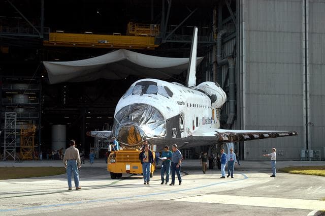 NASA image: KENNEDY SPACE CENTER, FLA. -  The orbiter Atlantis rolls out of the Vehicle Assembly Building for transfer back to the Orbiter Processing Facility.  Atlantis spent 10 days in the VAB to allow work to be performed in the OPF that can only be accomplished while the bay is empty. Work included annual validation of the bay's cranes, work platforms, lifting mechanisms and jack stands.  Work resumes to prepare Atlantis for launch in September 2004 on the first return-to-flight mission, STS-114.