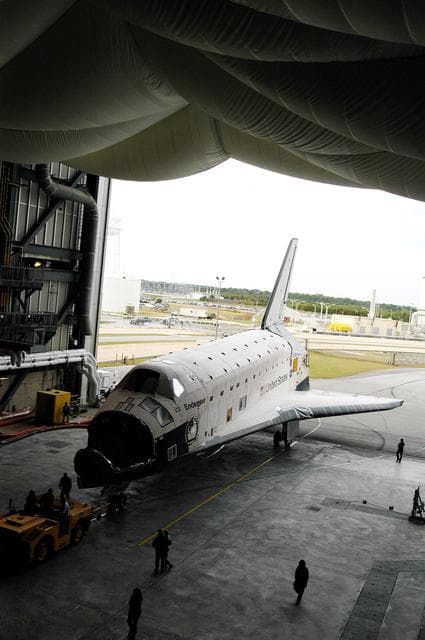 NASA image: KENNEDY SPACE CENTER, FLA. -- Endeavour rolls into the Vehicle Assembly Building (VAB) for temporary storage.  The orbiter has been moved from the Orbiter Processing Facility (OPF) to allow work to be performed in the OPF that can only be accomplished while the bay is empty. Work scheduled in the OPF includes annual validation of the bay’s cranes, work platforms, lifting mechanisms and jack stands. Endeavour will remain in the VAB for approximately 12 days, then return to the OPF.