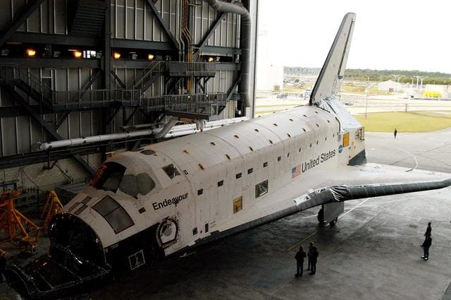 NASA image: KENNEDY SPACE CENTER, FLA. -- Endeavour rolls into the Vehicle Assembly Building (VAB) for temporary storage.  The orbiter has been moved from the Orbiter Processing Facility (OPF) to allow work to be performed in the OPF that can only be accomplished while the bay is empty. Work scheduled in the OPF includes annual validation of the bay’s cranes, work platforms, lifting mechanisms and jack stands. Endeavour will remain in the VAB for approximately 12 days, then return to the OPF.