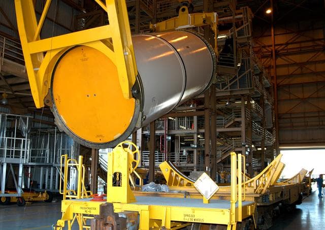 NASA image: KENNEDY SPACE CENTER, FLA. -  In the Rotation Processing and Surge Facility, an SRB solid segment is being rotated to horizontal for placement on a rail car.  The segment is being shipped to Utah for testing.  The segment was part of the STS-114 stack.  It is the first time actual flight segments that had been stacked for flight in the VAB are being returned to Utah for testing.  It will undergo firing, which will enable inspectors to check the viability of the solid and verify the life expectancy for stacked segments.
