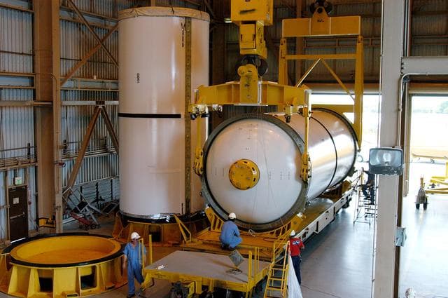 NASA image: KENNEDY SPACE CENTER, FLA. -  In the Rotation Processing and Surge Facility, an SRB solid segment is lowered onto a rail car for shipment to Utah where it will be tested.  The segment was part of the STS-114 stack.  It is the first time actual flight segments that had been stacked for flight in the VAB are being returned to Utah for testing.  It will undergo firing, which will enable inspectors to check the viability of the solid and verify the life expectancy for stacked segments.