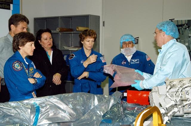 NASA image: KENNEDY SPACE CENTER, FLA. -  STS-114 Mission Specialist Andrew Thomas (right) shows some of the mission equipment to other crew members (from left) Wendy Lawrence, mission specialist; Eileen Collins, commander; and Charles Camarda, mission specialist.  Crew members are at KSC for equipment familiarization.  STS-114 is classified as Logistics Flight 1 to the International Space Station, delivering new supplies and replacing one of the orbital outpost’s Control Moment Gyroscopes (CMGs). STS-114 will also carry a Raffaello Multi-Purpose Logistics Module and the External Stowage Platform-2.  The crew is slated to conduct at least three spacewalks: They will demonstrate repair techniques of the Shuttle’s Thermal Protection System,  replace the failed CMG with one delivered by the Shuttle, and  install the External Stowage Platform.