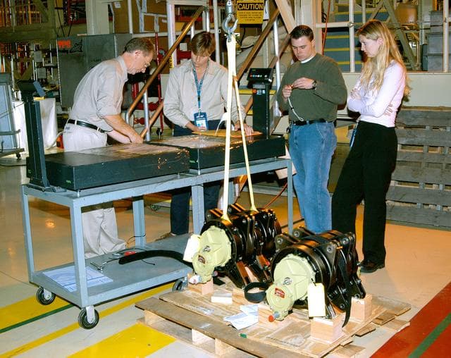 NASA image: KENNEDY SPACE CENTER, FLA. -  Workers in the Orbiter Processing Facility get ready to measure the alignment of the bearings on the rudder speed brake actuators sitting on the floor in the foreground.  The actuators move an orbiter’s rudder, speed brake, elevons and main engines during flight.