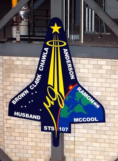 NASA image: KENNEDY SPACE CENTER, FLA. -  A 20-foot by 15-foot replica of the STS-107 logo has been installed above the “A” on the A tower in the transfer aisle of the Vehicle Assembly Building.  The debris from the orbiter Columbia, lost in a tragic accident on its return to Earth from the STS-107 mission, is permanently stored in the tower.  A dedication ceremony Jan. 29, 2004, unveiled a plaque being installed in the storage area in honor of “Columbia, the crew of STS-107, and their loved ones.”
