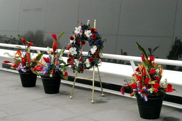 NASA image: KENNEDY SPACE CENTER, FLA. - A wreath and other floral arrangements rest beneath the Astronaut Memorial Mirror at the KSC Visitor Complex following a memorial service held for the crew of Columbia on the anniversary of the tragic accident that took their lives Feb. 1, 2003.  The service included comments by Center Director Jim Kennedy, Deputy Director Woodrow Whitlow Jr., Executive Director of Florida Space Authority Winston Scott, and Dr. Stephen Feldman, president of the Astronaut Memorial Foundation, who placed the wreath at the mirror.  The black granite mirror honors astronauts, whose names are carved in the surface, who have given their lives for space exploration.