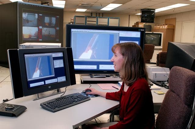 NASA image: KENNEDY SPACE CENTER, FLA. - One of the world’s highest performing visual film analysis systems, developed to review and analyze previous shuttle flight data (shown here) in preparation for the shuttle fleet’s return to flight, is being used today for another purpose.  NASA has permitted its use in helping to analyze a film that shows a recent kidnapping in progress in Florida.  The system, developed by NASA, United Space Alliance (USA) and Silicon Graphics Inc., allows multiple-person collaboration,  highly detailed manipulation and evaluation of specific imagery.  The system is housed in the Image Analysis Facility inside the Vehicle Assembly Building. [Photo taken Aug. 15, 2003, courtesy of Terry Wallace, SGI ]