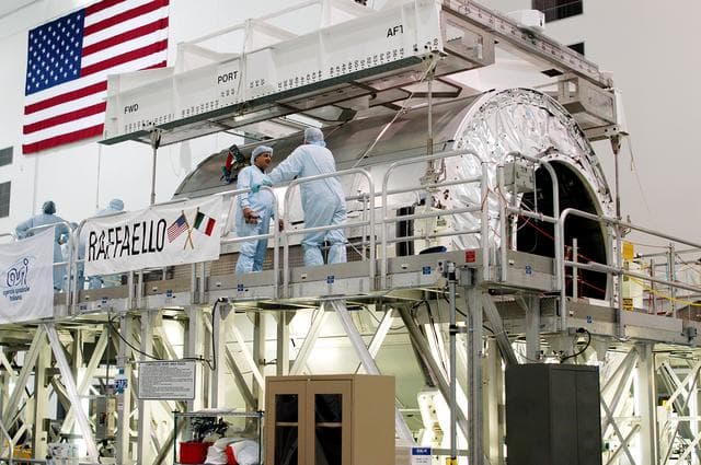 NASA image: KENNEDY SPACE CENTER, FLA. - An overhead crane is attached to the Multi-Purpose Logistics Module Raffaello in order to move it to another work stand in the Space Station Processing Facility.  Raffaello is the second MPLM built by the Italian Space Agency, serving as a reusable logistics carrier and primary delivery system to resupply and return station cargo requiring a pressurized environment.  It is being moved to allow the third MPLM, Donatello, to be brought in for routine testing.  Donatello has been stored in the Operations and Checkout Building.  This is the first time all three MPLMs are in the SSPF; the other one is the Leonardo.  Raffaello is scheduled to fly on Space Shuttle Atlantis on mission STS-114.