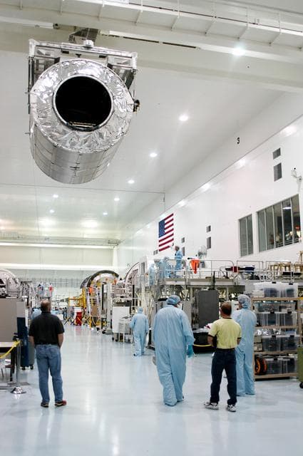 NASA image: KENNEDY SPACE CENTER, FLA. - Workers on the floor of the Space Station Processing Facility watch as overhead cables carry the Multi-Purpose Logistics Module Donatello to a work stand.  Previously housed in the Operations and Checkout Building, Donatello was brought into the SSPF for routine testing.  This is the first time all three MPLMs (Donatello, Raffaello and Leonardo) are in the SSPF.  The MPLMs were built by the Italian Space Agency, to serve as reusable logistics carriers and the primary delivery system to resupply and return station cargo requiring a pressurized environment.  The third MPLM, Raffaello is scheduled to fly on Space Shuttle Atlantis on mission STS-114.