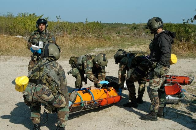 NASA image: KENNEDY SPACE CENTER, FLA. - A helicopter rescue team prepares another “injured” astronaut for transportation to a local hospital.  They are all taking part in a “Mode VII” emergency landing simulation at Kennedy Space Center.  The purpose of the Mode VII is to exercise emergency preparedness personnel, equipment and facilities in rescuing astronauts from a downed orbiter and providing immediate medical attention.  This simulation presents an orbiter that has crashed short of the Shuttle Landing Facility in a wooded area 2-1/2 miles south of Runway 33.  Emergency crews are responding to the volunteer “astronauts” who are simulating various injuries inside the crew compartment mock-up.  Rescuers must remove the crew, provide triage and transport to hospitals those who need further treatment.  Local hospitals are participating in the exercise.