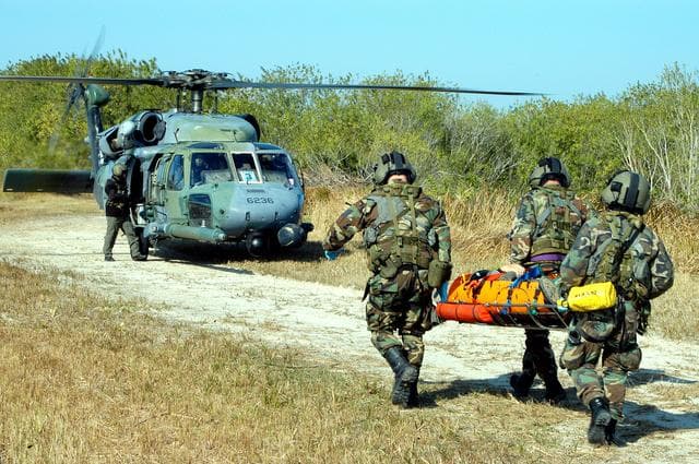 NASA image: KENNEDY SPACE CENTER, FLA. - A helicopter rescue team carries another “injured” astronaut to a helicopter for transportation to a local hospital.  They are all taking part in a “Mode VII” emergency landing simulation at Kennedy Space Center.  The purpose of the Mode VII is to exercise emergency preparedness personnel, equipment and facilities in rescuing astronauts from a downed orbiter and providing immediate medical attention.  This simulation presents an orbiter that has crashed short of the Shuttle Landing Facility in a wooded area 2-1/2 miles south of Runway 33.  Emergency crews are responding to the volunteer “astronauts” who are simulating various injuries inside the crew compartment mock-up.  Rescuers must remove the crew, provide triage and transport to hospitals those who need further treatment.  Local hospitals are participating in the exercise.