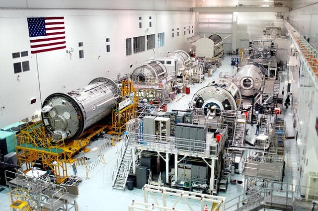 NASA image: KENNEDY SPACE CENTER, FLA. - This view reveals all three Multi-Purpose Logistics Modules on the floor of the Space Station Processing Facility.  This is the first time all three - Leonardo, Raffaello and Donatello -- have been in one location.  Donatello has been stored in the Operations and Checkout Building since its arrival at KSC and was brought into the SSPF for routine testing. The MPLMs were built by the Italian Space Agency, to serve as reusable logistics carriers and the primary delivery system to resupply and return station cargo requiring a pressurized environment.  Raffaello is scheduled to fly on Space Shuttle Atlantis on mission STS-114.