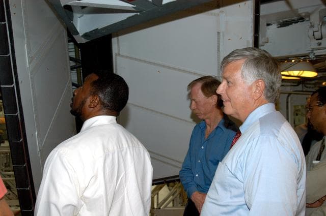 NASA image: KENNEDY SPACE CENTER, FLA. - On a tour of the Orbiter Processing Facility, Center Director Jim Kennedy (right) and Deputy Director Woodrow Whitlow Jr. (left) look at rudder speed brake panels on Endeavour  In the background is Tom Roberts, who is with United Space Alliance.  Endeavour is in its Orbiter Major Modification period, which began in December 2003.