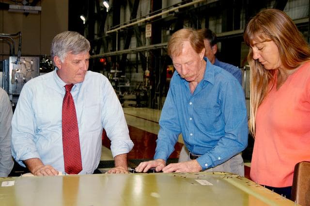 NASA image: KENNEDY SPACE CENTER, FLA. - On a tour of the Orbiter Processing Facility, Center Director Jim Kennedy (left) looks at an external tank door corrosion work being done on Endeavour.  At right, Tom Roberts, Airframe Engineering System specialist with United Space Alliance, is describing the work. At right is Kathy Laufenberg, Orbiter Airframe Engineering ground area manager,also with USA.  Endeavour is in its Orbiter Major Modification period, which began in December 2003.