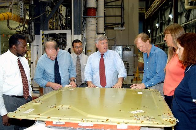 KENNEDY SPACE CENTER, FLA. - On a tour of the Orbiter Processing Facility, Center Director Jim Kennedy (center) and Deputy Director Woodrow Whitlow Jr. (far left) look at the external tank door corrosion work being done on Endeavour.  Next to Whitlow is Bruce Buckingham, assistant to the deputy director.  Providing information, at right, are Orbiter Airframe Engineering ground area manager, and Tom Roberts, Airframe Engineering System specialist, both with United Space Alliance; and Joy Huff, with KSC Space Shuttle Processing.  Endeavour is in its Orbiter Major Modification period, which began in December 2003.