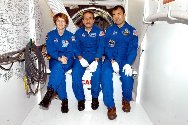 NASA image: KENNEDY SPACE CENTER, FLA. - STS-114 Commander Eileen Collins and Mission Specialists Charles Camarda and Soichi Noguchi sit outside the crew hatch on the orbiter Discovery.  Noguchi is with the Japanese Aerospace and Exploration Agency.   They and other crew members are at KSC becoming familiar with Shuttle and mission equipment. The mission is Logistics Flight 1, which is scheduled to deliver supplies and equipment plus the external stowage platform to the International Space Station.