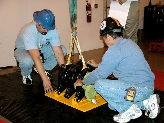 NASA image: KENNEDY SPACE CENTER, FLA. -  Workers at Cape Canaveral Air Force Station place one of four rudder speed brake actuators onto a pallet for X-ray.  The actuators, to be installed on the orbiter Discovery, are being X-rayed at the Radiographic High-Energy X-ray Facility to determine if the gears were installed correctly. Discovery has been assigned to the first Return to Flight mission, STS-114, a logistics flight to the International Space Station.