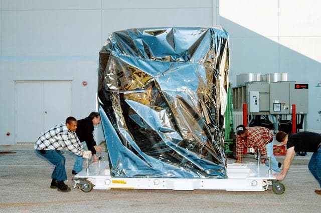 NASA image: KENNEDY SPACE CENTER, FLA. -  At the Astrotech Space Operations processing facilities near KSC, workers check the moveable pallet holding NASA’s MESSENGER spacecraft.  MESSENGER - short for MErcury Surface, Space ENvironment, GEochemistry and Ranging - will be taken into a high bay clean room and employees of the Johns Hopkins University Applied Physics Laboratory, builders of the spacecraft, will perform an initial state-of-health check.  Then processing for launch can begin, including checkout of the power systems, communications systems and control systems.  The thermal blankets will also be attached for flight.  MESSENGER will be launched May 11 on a six-year mission aboard a Boeing Delta II rocket.  Liftoff is targeted for 2:26 a.m. EDT on Tuesday, May 11.