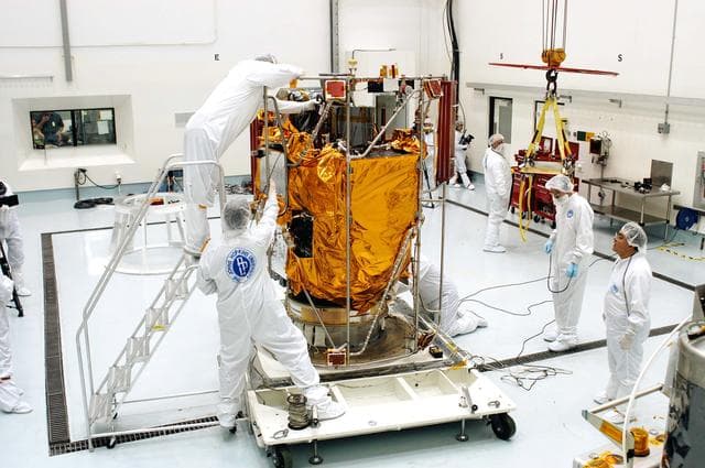 NASA image: KENNEDY SPACE CENTER, FLA. -  In the high bay clean room at the Astrotech Space Operations processing facilities near KSC, workers prepare to attach an overhead crane to NASA’s MESSENGER spacecraft.  The spacecraft will be moved to a work stand where employees of the Johns Hopkins University Applied Physics Laboratory, builders of the spacecraft, will perform an initial state-of-health check.  Then processing for launch can begin, including checkout of the power systems, communications systems and control systems.  The thermal blankets will also be attached for flight.  MESSENGER - short for MErcury Surface, Space ENvironment, GEochemistry and Ranging - will be launched May 11 on a six-year mission aboard a Boeing Delta II rocket.  Liftoff is targeted for 2:26 a.m. EDT on Tuesday, May 11.