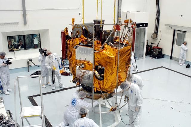 NASA image: KENNEDY SPACE CENTER, FLA. -  At the Astrotech Space Operations processing facilities, workers check the placement of NASA’s MESSENGER spacecraft on a work stand. There employees of the Johns Hopkins University Applied Physics Laboratory, builders of the spacecraft, will perform an initial state-of-health check.  Then processing for launch can begin, including checkout of the power systems, communications systems and control systems.  The thermal blankets will also be attached for flight.  MESSENGER - short for MErcury Surface, Space ENvironment, GEochemistry and Ranging - will be launched May 11 on a six-year mission aboard a Boeing Delta II rocket.  Liftoff is targeted for 2:26 a.m. EDT on Tuesday, May 11.