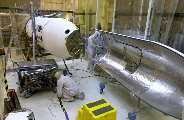 Technicians prepare the AIM spacecraft for fairing installation
