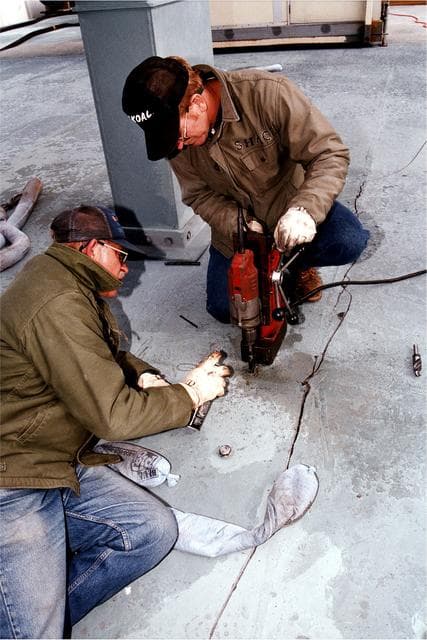 NASA image: KENNEDY SPACE CENTER, FLA. -  United Space Alliance (USA) workers J.D. Wise, left, and Robert Shackelford, with drill, try to stop an approximately 24-foot-long crack from getting any bigger on the Mobile Launcher Platform (MLP), which is holding the Space Shuttle Discovery en route to Launch Pad 39A for the STS-82 mission. Discovery was on its way out to the launch pad when engineers heard a loud bang and noticed that a crack had developed on the MLP. Rollout had begun shortly after 7 a.m. EST and was stopped at about 8:25 a.m.  This Y-shaped crack is on the MLP surface and runs from near the left-hand solid rocket booster flame hole toward the near corner of the MLP.  Rollout of Discovery resumed just past noon after structural engineers determined that the integrity of the MLP had not been compromised.  Discovery is scheduled to lift off on the second Hubble Space Telescope servicing mission on Feb. 11.