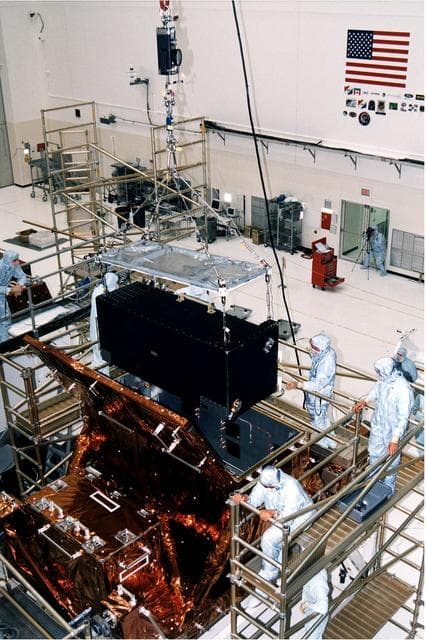 NASA image: KENNEDY SPACE CENTER, FLA. -  Workers in KSC's Vertical Processing Facility lower the Near Infrared Camera and Multi-Object Spectrometer (NICMOS) into the Second Axial Carrier.  NICMOS is one of two new scientific instruments that will replace two outdated instruments on the Hubble Space Telescope (HST).  NICMOS will provide HST with the capability for infrared imaging and spectroscopic observations of astronomical targets.  The refrigerator-sized NICMOS is HST's first cryogenic instrument -- its sensitive infrared detectors must operate at very cold temperatures of minus 355 degrees Fahrenheit or 58 derees Kelvin.  NICMOS will be installed in Hubble during STS-82, the second Hubble Space Telescope servicing mission.  Liftoff is targeted Feb. 11 aboard Discovery with a crew of seven.